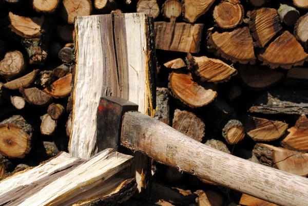 Eisenaxt hackt Holzstamm mit Holzstämmen auf Hintergrund — Stockfoto