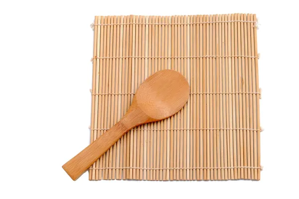 Cucchiaio di legno sopra la tovaglietta di bambù — Foto Stock