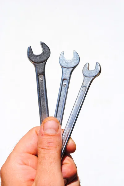 La mano del hombre sostiene la herramienta de tres llaves — Foto de Stock