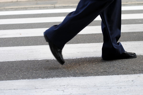Classic urban zebra crossing with business man feet