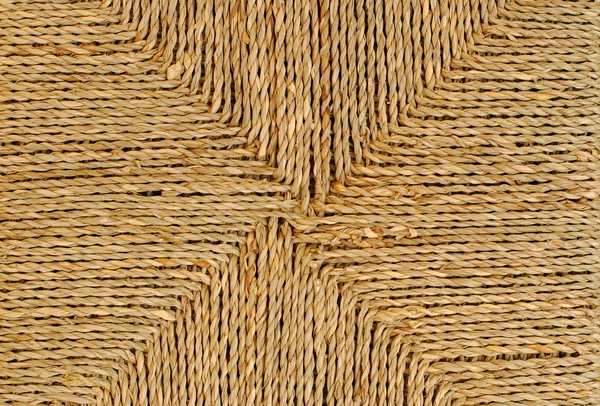 Плетеная корзина с оригинальным рисунком, соломенный фон — стоковое фото