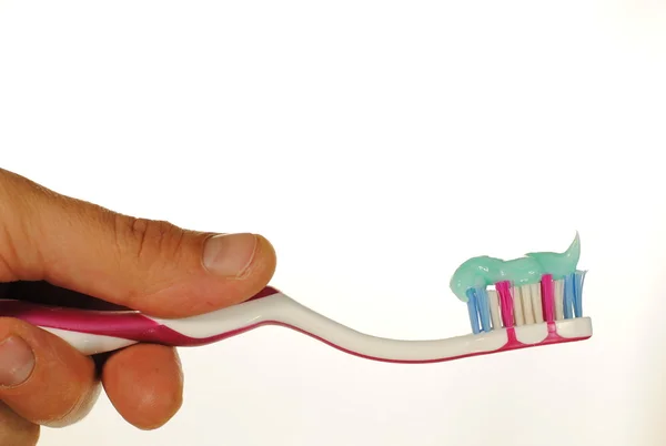 Мужская рука держит зубную щетку с зубной пастой — стоковое фото