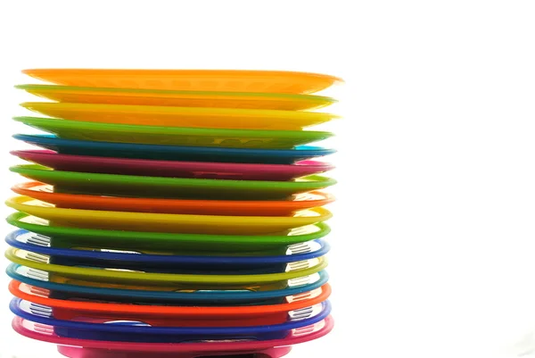 Набор цветных пластиковых тарелок на белом фоне — стоковое фото