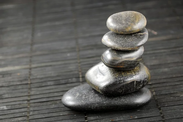 Zwarte zen stenen op bamboe placemat, concept van evenwicht — Stockfoto