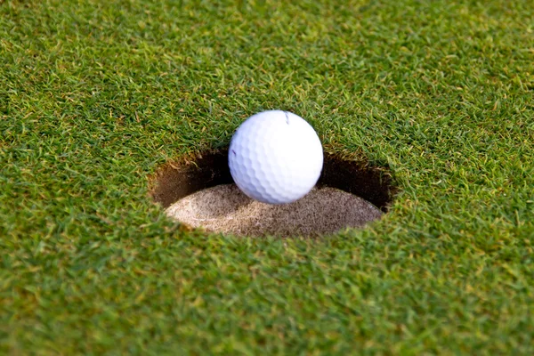 Bola de golfe está indo em um buraco — Fotografia de Stock