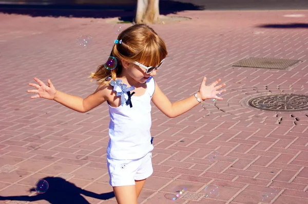 La chica jugando con burbujas de jabón — Foto de Stock