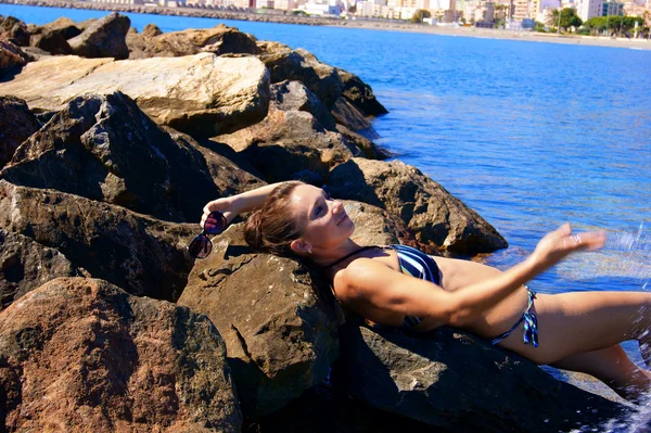 Flickan liggande på en sten — Stockfoto