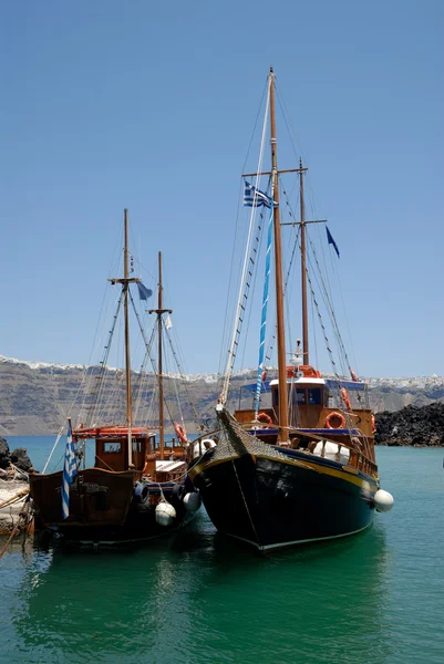 Традиционные салютные лодки на якоре на острове Неа-Камени на Санторини, Дж. — стоковое фото