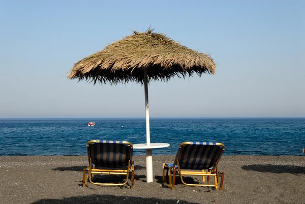 Sedie a sdraio sulla spiaggia Kamari a Santorini, Grecia — Foto Stock