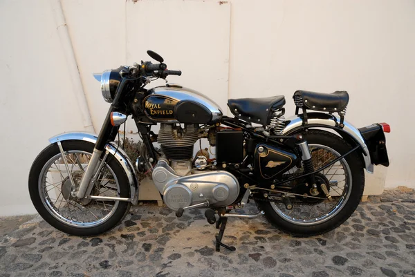 Старый мотоцикл, припаркованный на стене — стоковое фото