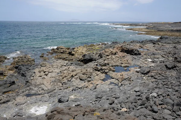 Vulkanische schwarze Steine an der Küste von Fuerteventura, Kanarische Inseln Spanien — Stockfoto