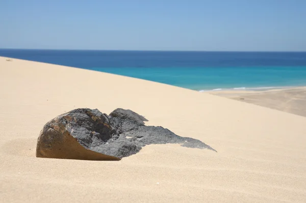 Volcanic black stone in sand of dune on Canary Island Fuerteventura, Spain — Stock Photo, Image