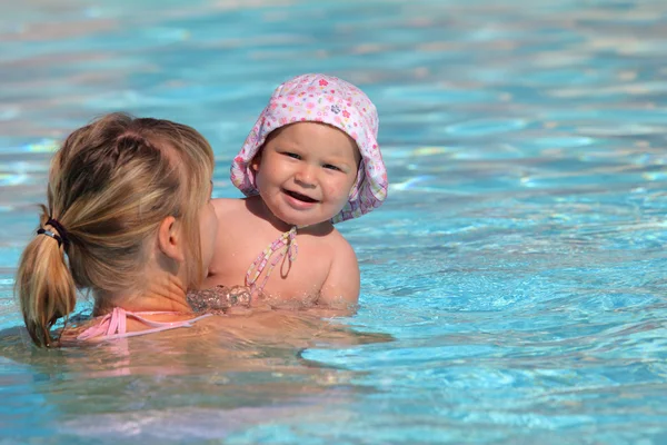 Yürümeye başlayan çocuk kızı bir yüzme havuzu ile anne Stok Resim