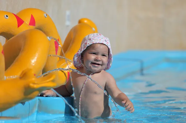 Cute toddler girl playing in a swimming pool — Stock Photo, Image