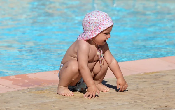 Мила дівчинка-малюк грає в басейні — стокове фото