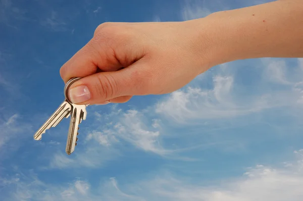 Dela med nycklar mot blå himmel — Stockfoto