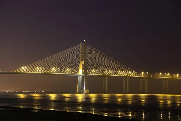 Мост Васко да Гама освещенный ночью, Лиссабон Португалия — стоковое фото