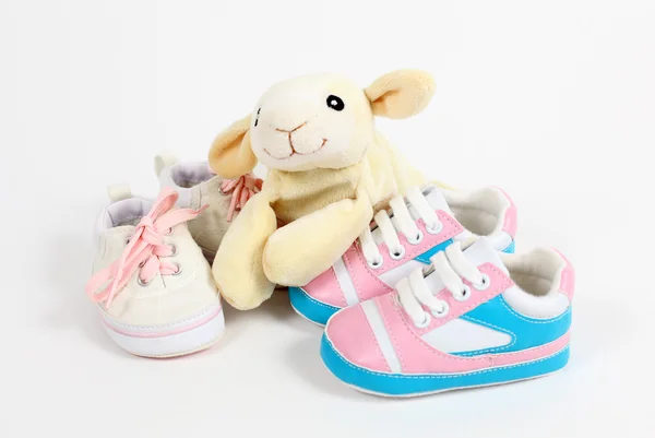Little baby shoes and sheep over white background — Stock Photo, Image