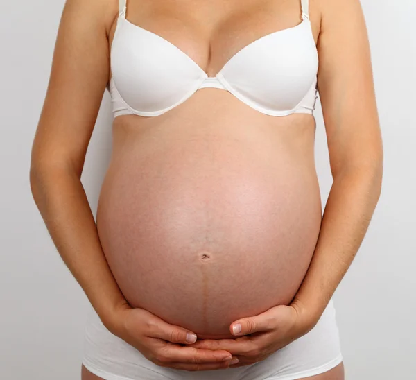 Unga gravid kvinna i vita underkläder — Stockfoto