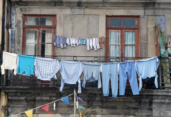 stock image Washed clothes drying outside of an old house