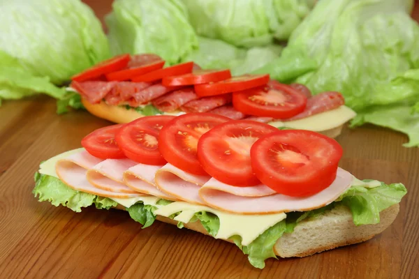 Sanduíches frescas com peito de peru, tomates, suíços e salame — Fotografia de Stock