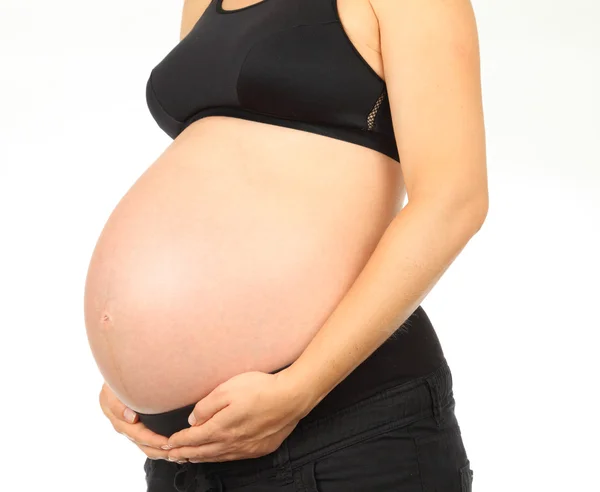 Młoda kobieta w ciąży posiada jej brzuch — Zdjęcie stockowe