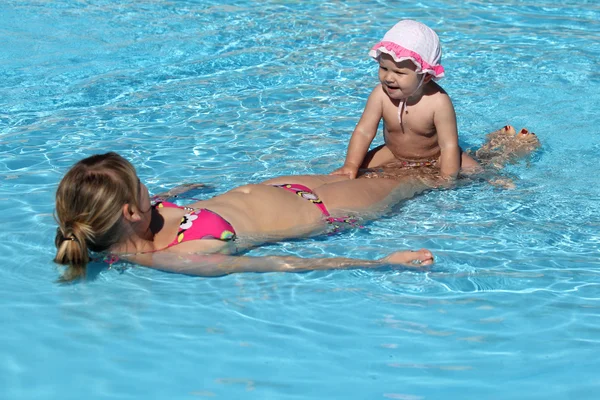 Mother and daughter having fun in a swimming pool — Stock Photo, Image