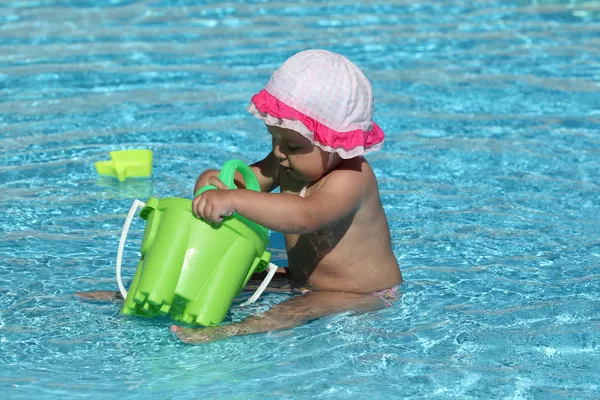 Menina bonito brincando em uma piscina — Fotografia de Stock
