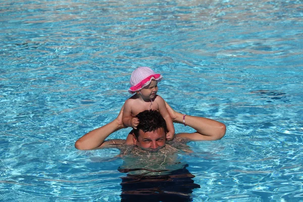 Padre e hija divirtiéndose en una piscina — Foto de Stock