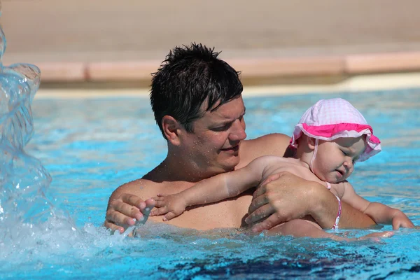 Padre e hija divirtiéndose en una piscina — Foto de Stock