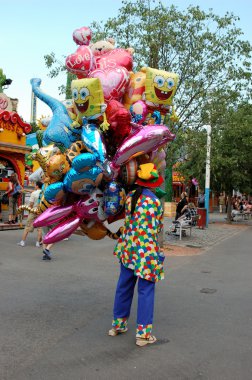 Clown with brightly colored baloons clipart