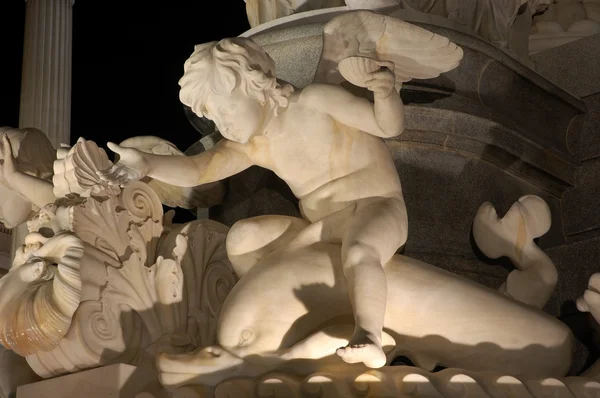 Geceleri aydınlatılan yunus sürme bir erkek heykeli — Stok fotoğraf