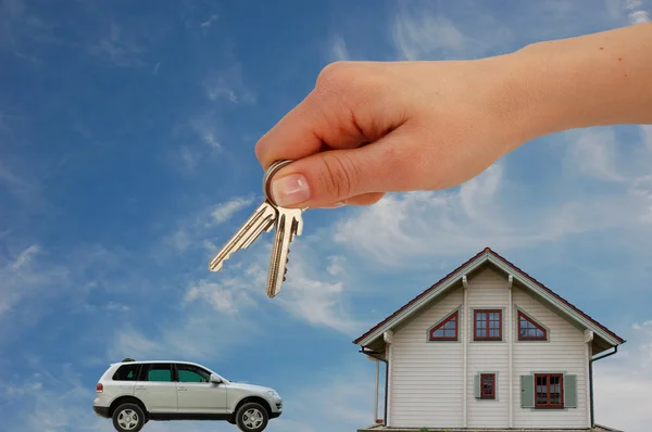 Mão com chaves para casa nova e carro — Fotografia de Stock