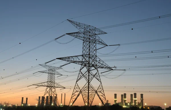 Strommast und Elektrizitätswerk im Hintergrund bei Sonnenuntergang — Stockfoto