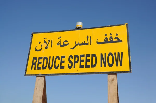 Vermindering van de snelheid nu teken in Engels en Arabisch taal, dubai — Stockfoto