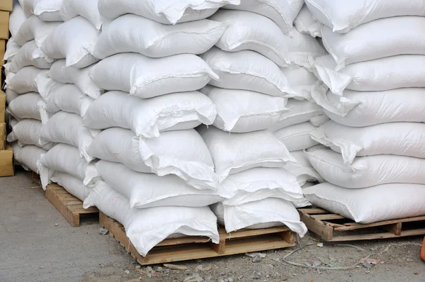 Stacked white sacks at storehouse — Zdjęcie stockowe