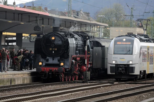 Viejos y nuevos. Tren de vapor en la estación de tren — Foto de Stock