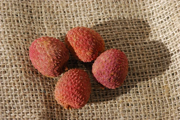 Çuval bezi üzerinde dört lychees — Stok fotoğraf
