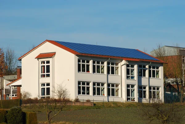 Budynek z paneli słonecznych na dachu — Zdjęcie stockowe