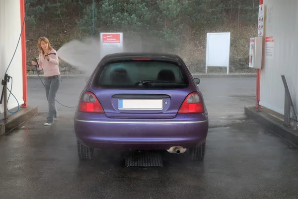 Jovem mulher lavando seu carro — Fotografia de Stock