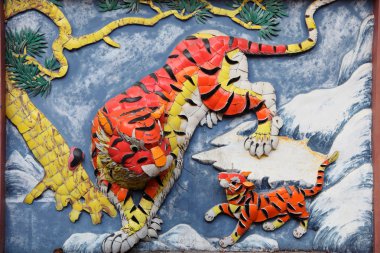 Tiger family on the wall of taoist temple in Hong Kong clipart