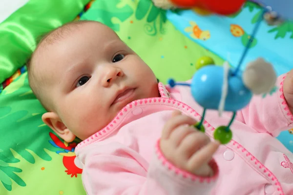 Младенец, играющий на цветном одеяле — стоковое фото