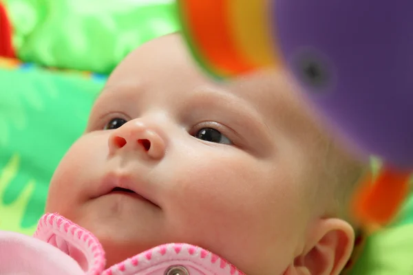 Porträtt av en liten baby omgiven av leksaker — Stockfoto