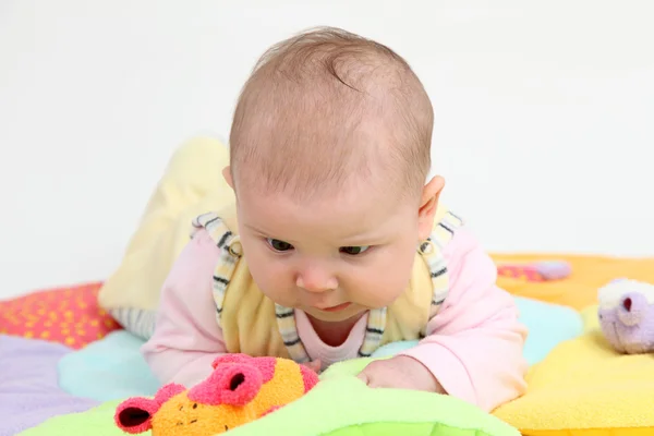 Pequeño bebé jugando en una manta colorida — Foto de Stock