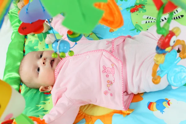Младенец, играющий на цветном одеяле — стоковое фото