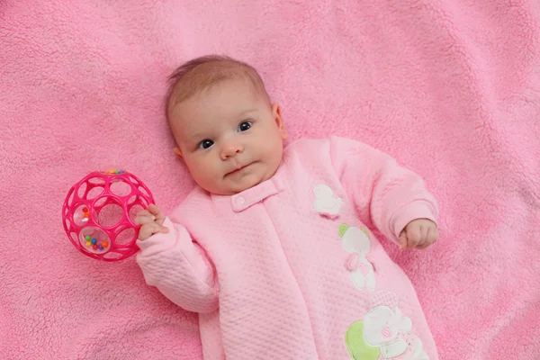 Bebé jugando en una manta rosa — Foto de Stock