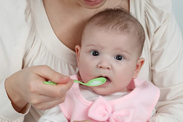 Madre alimenta a su pequeño bebé con cuchara — Foto de Stock