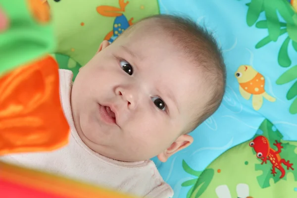 Porträtt av en liten baby omgiven av leksaker — Stockfoto