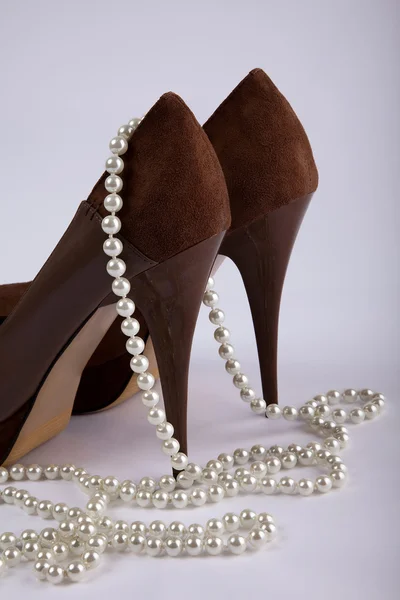 Обувь на высоком каблуке с жемчужным ожерельем — стоковое фото