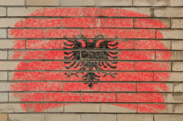 Флаг альбании на гранжевой кирпичной стене, покрашенный мелом — стоковое фото